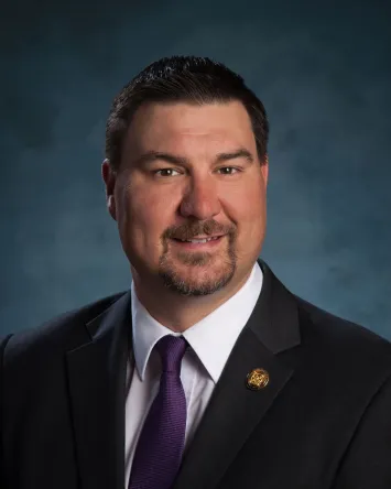 Professional man in suit with purple tie smiling