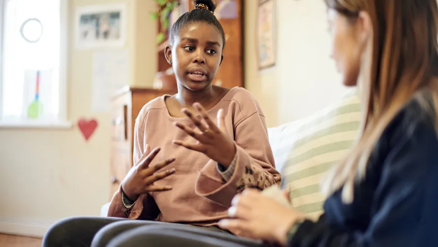 Photo of teen girl talking to an adult