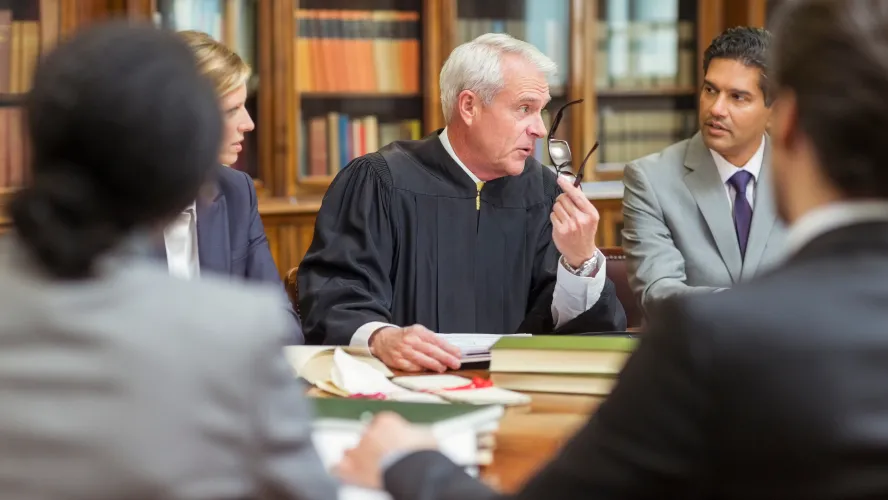 Judge leading legal discussion with diverse courtroom team