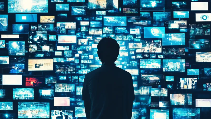 Person looking at wall of monitors and screens