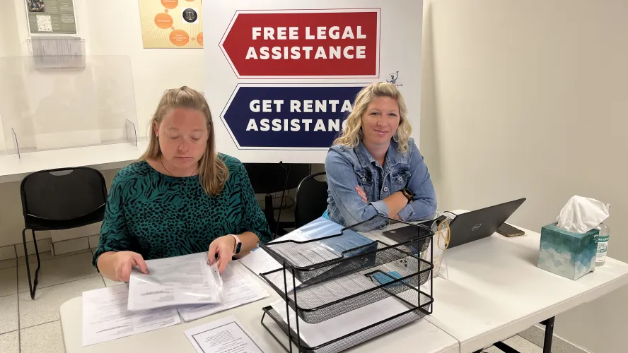 Two women at eviction diversion check-in desk