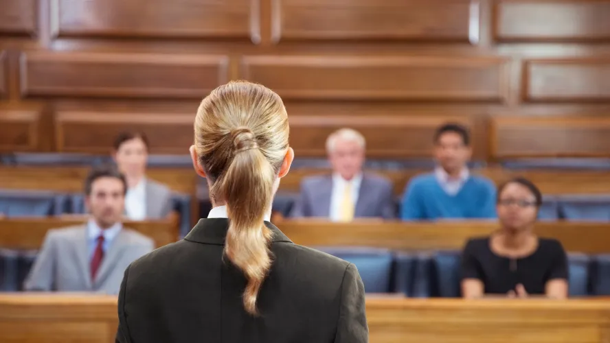 Female lawyer addressing diverse jury in courtroom setting