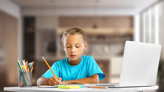 A girl at a computer studying and writing