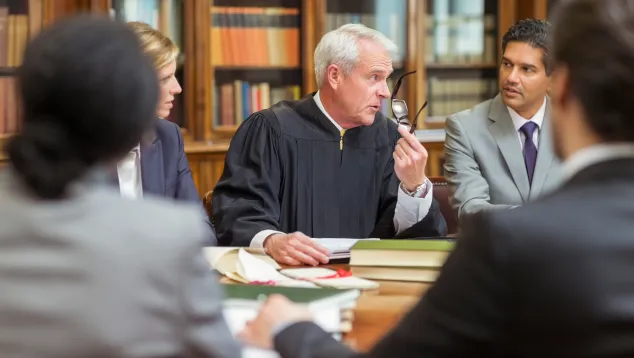 Judge leading legal discussion with diverse courtroom team