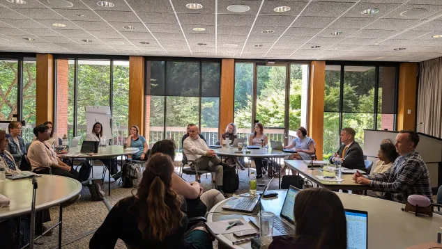 A group of people in an in-person class at NCSC headquarters having a discussion.