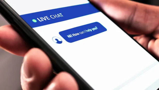 Smartphone showing live chat message, "Hi! How can I help you?"