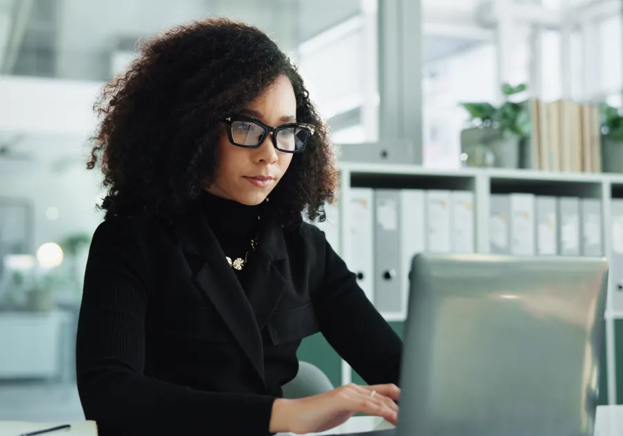 Woman working on laptop in modern office environment