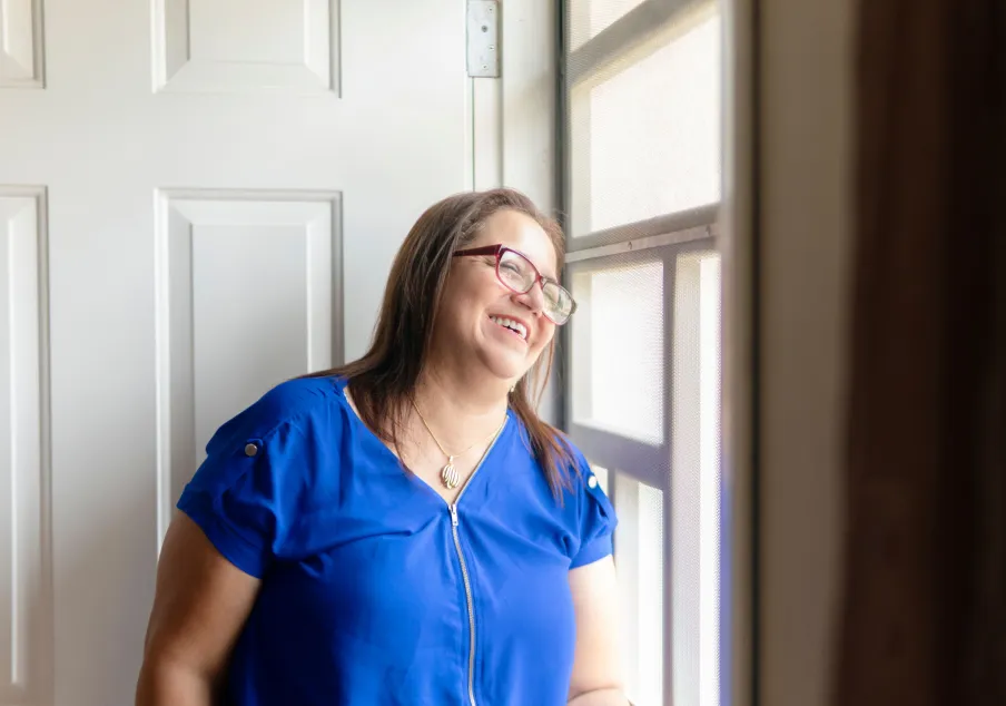 Hopeful woman looking out window