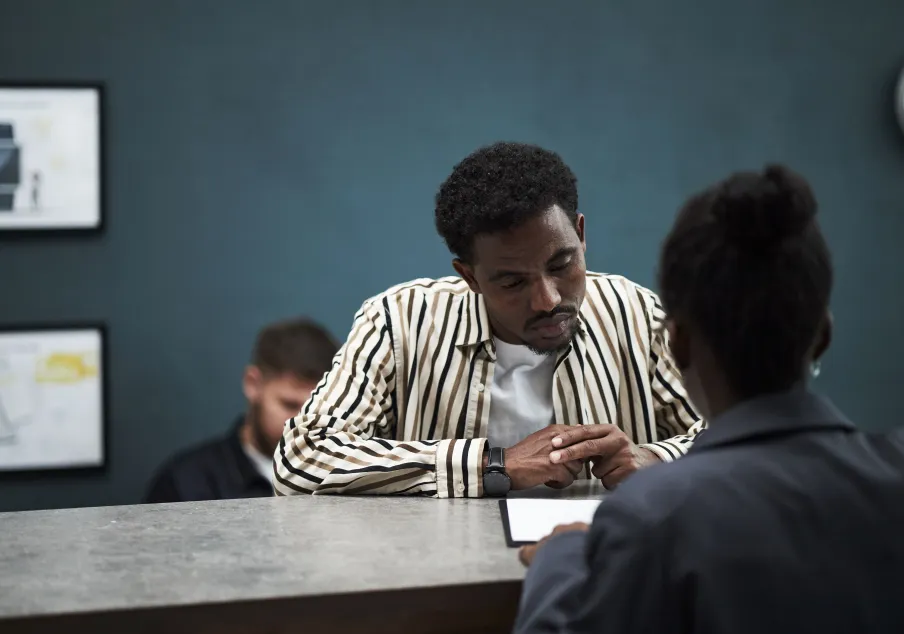 Photo of man at a service counter receiving assistance