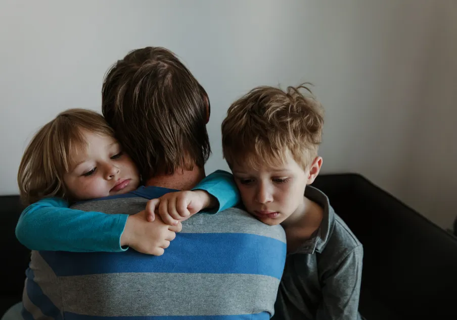 Sad girl and boy hugging father