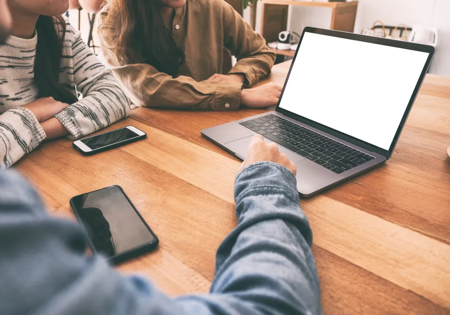 People reviewing information on laptop with blank screen