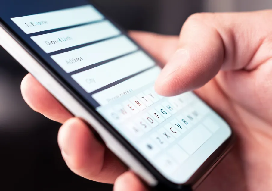 Person entering personal information on a smartphone form.