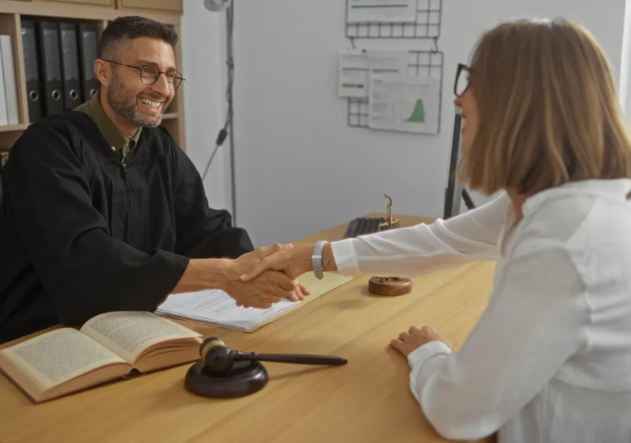 A judge shaking the hand of hired employee.