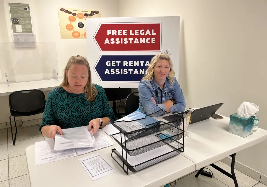 Two women at eviction diversion check-in desk