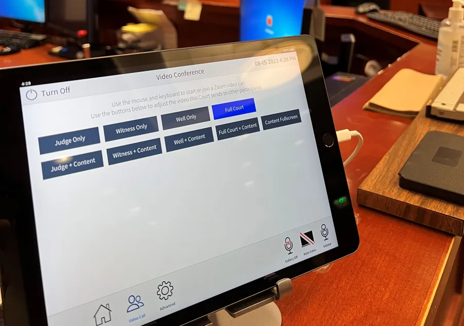 Tablet displaying video conference options in courtroom setting