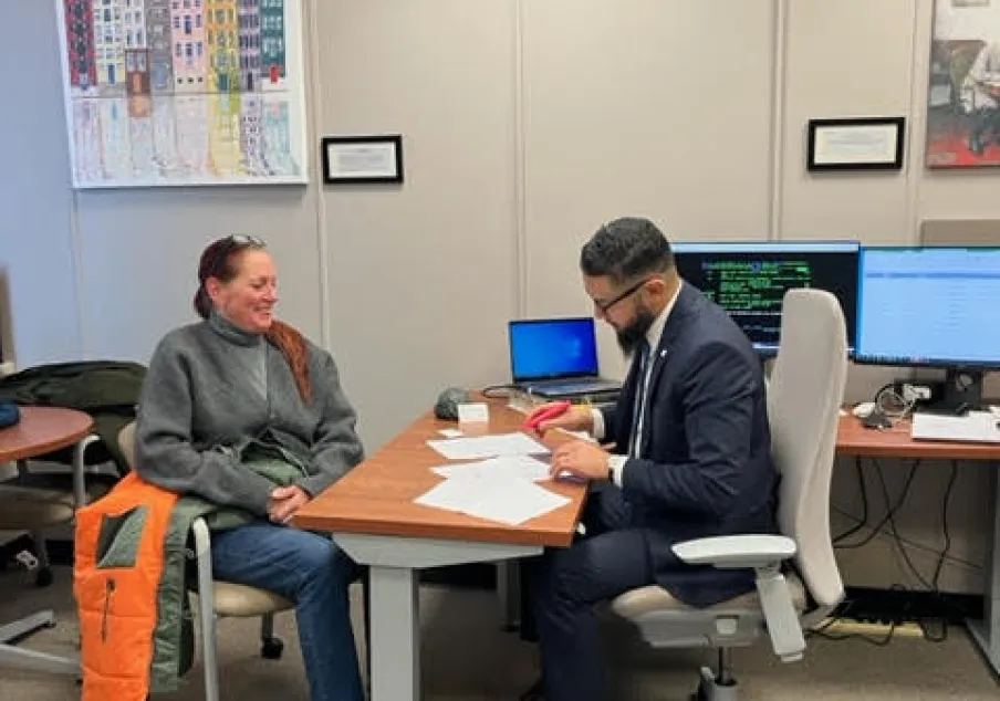 Courtroom staff assisting a woman at office desk