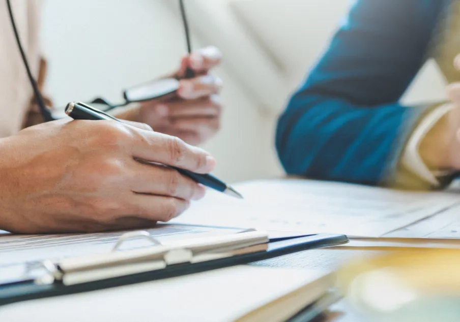 People reviewing legal documents at a meeting table.