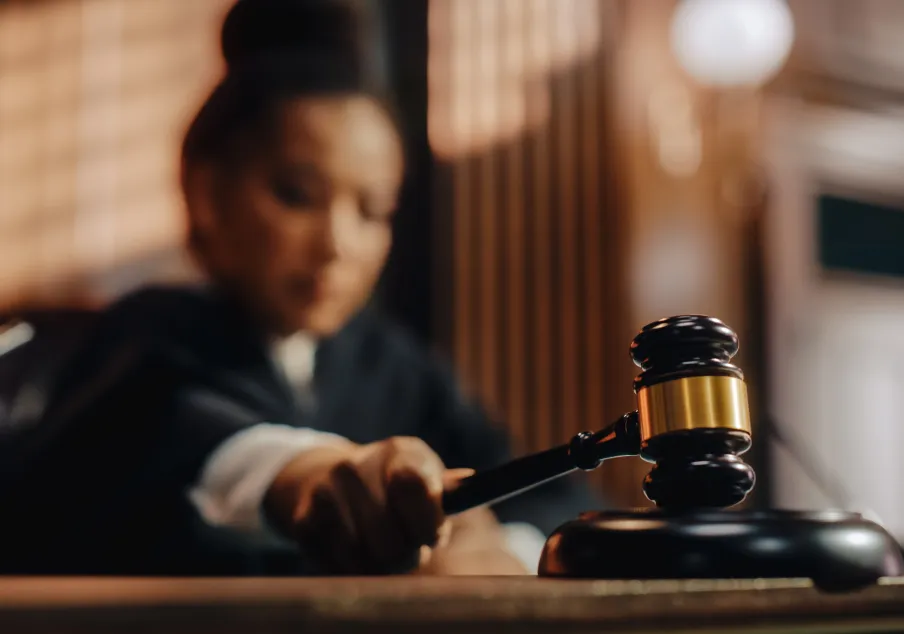 A judge banging a gavel on the court bench.