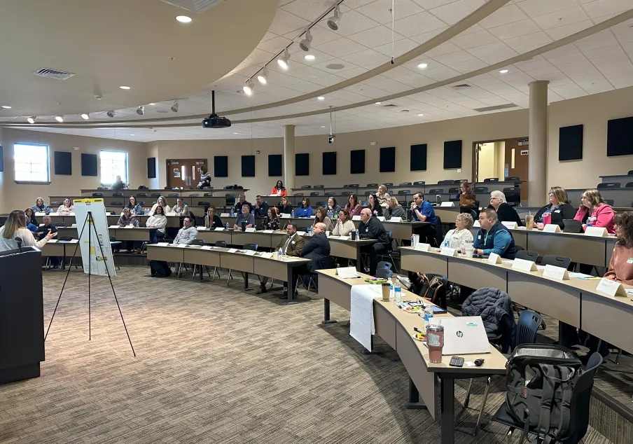 Conference attendees listening to a presentation in auditorium