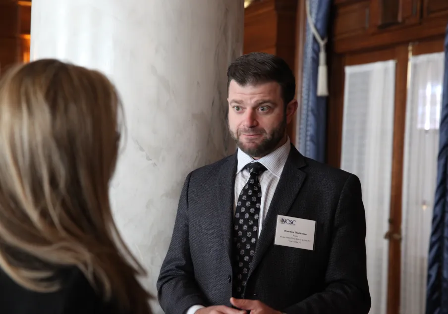 Man speaking with a woman at meeting
