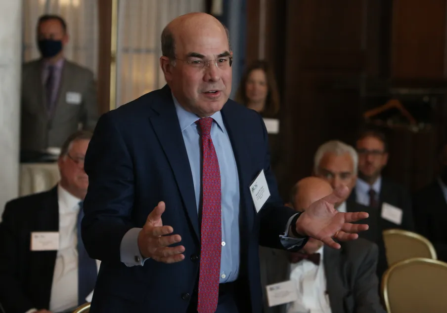 Man speaking at professional conference with audience listening