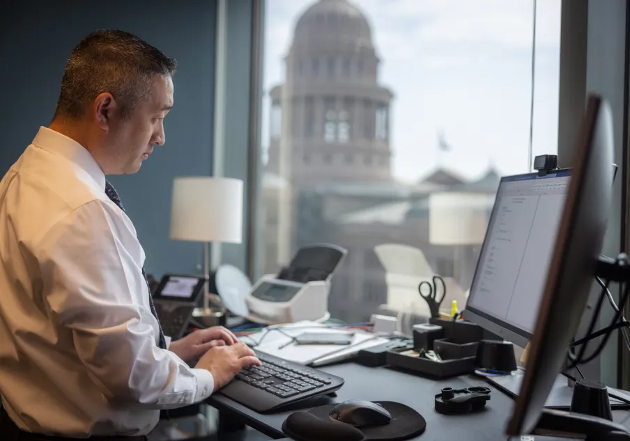 Man working on computer in office near courthouse window
