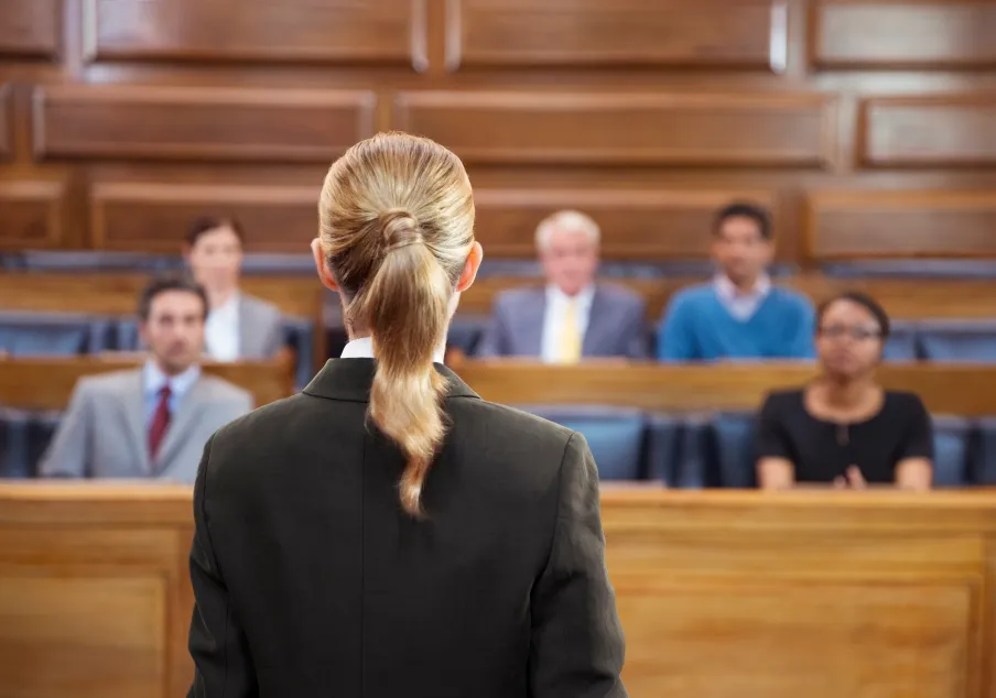 Female lawyer addressing diverse jury in courtroom setting