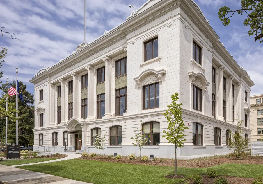 Historic Supreme Court building exterior with flags and landscaping