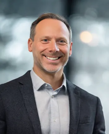 Smiling man in blazer with blurred background lights