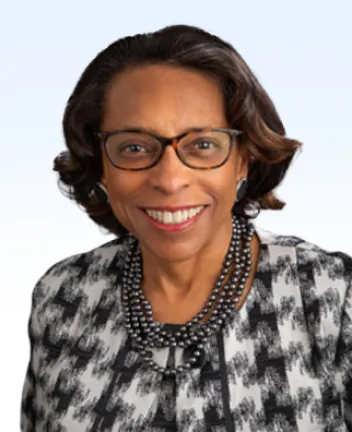 Professional woman smiling wearing glasses and necklace