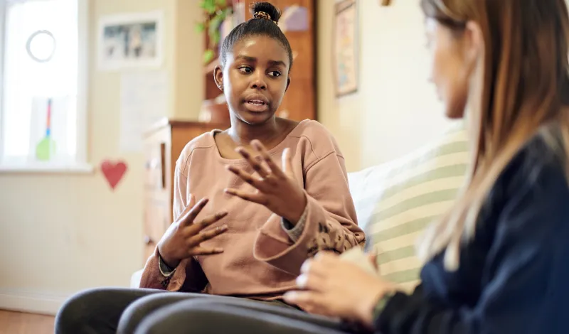 Photo of teen girl talking to an adult