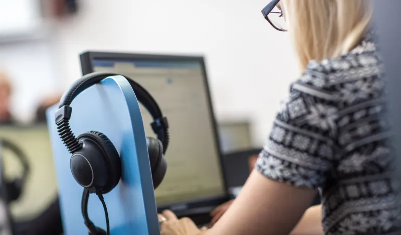 Female interpreter at computer with headset 