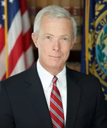 Professional portrait of man with U.S. flags background