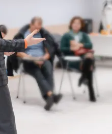 Presenter addressing seated audience in classroom setting