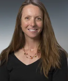 Professional headshot of woman with long hair smiling