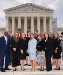 Group of diverse professionals standing on steps in front of courthouse