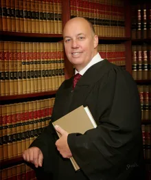 Judge in robes holding book in law library